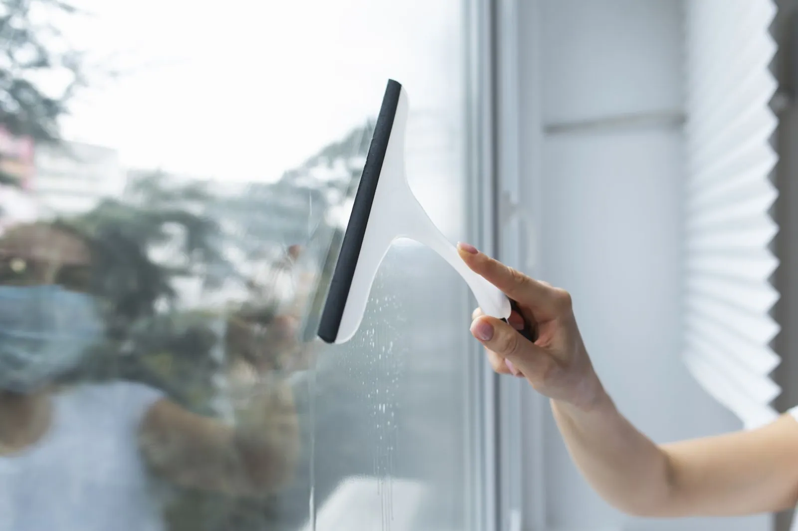 Cleaning a window pane with a squeegee